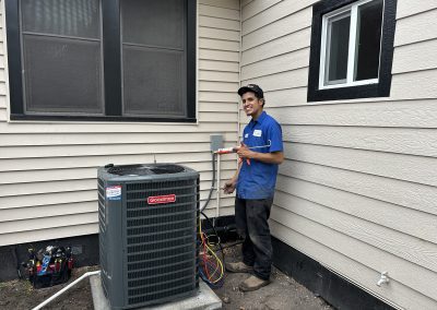 Classic Services technician servicing Goodman AC unit outside